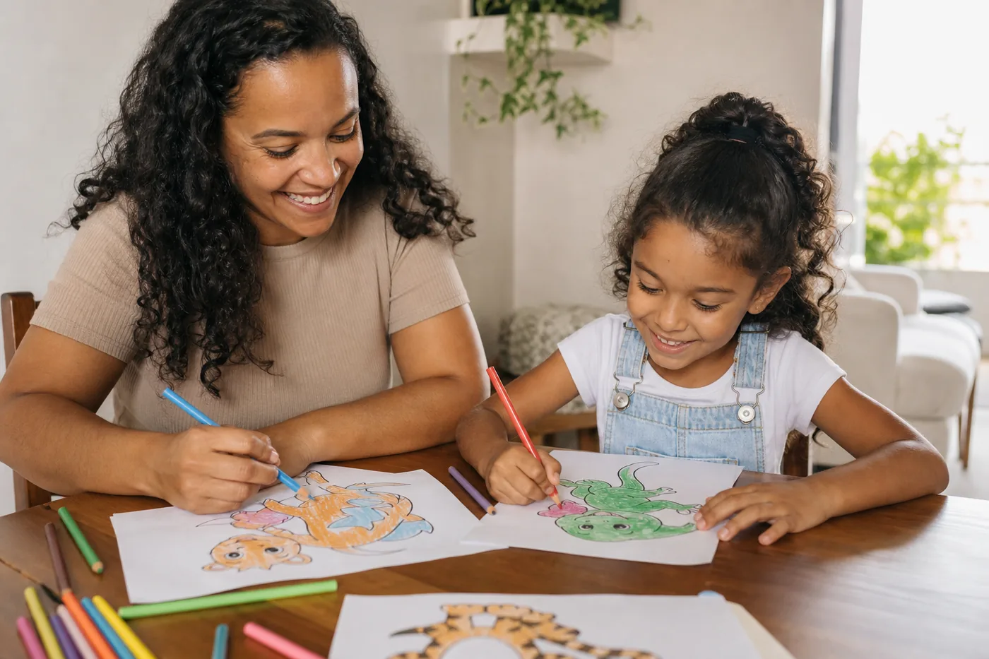 Responsável e criança colorindo juntos desenhos de animais em uma mesa